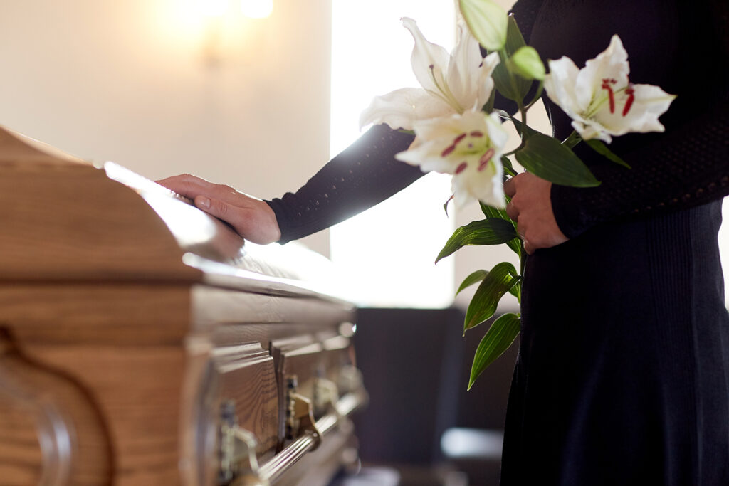 woman with lily flowers and coffin at funeral 2022 10 07 03 21 31 utc